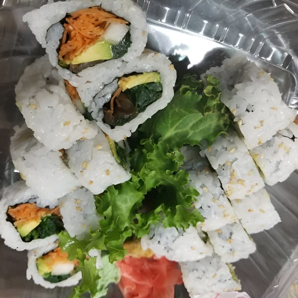 Spikey Ty's Asian cuisine features sushi rolls with avocado, carrots, and greens, served with lettuce and ginger.